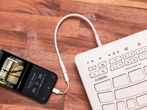 Compact Finger Drum Pad with 18 Touch Sensitive Pads, USB connectivity to a smartphone, on a wooden surface.