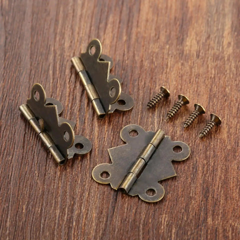 Mini Butterfly Door Hinge Set Antique Bronze 20 By 25mm shown with screws on wood surface.
