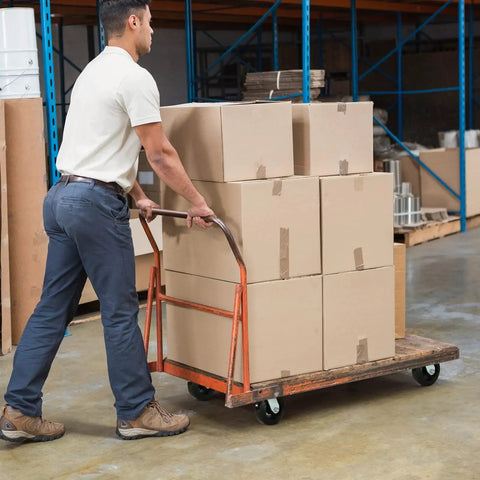 Person pushing a cart with boxes, fitted with heavy duty 6 inch rubber on cast iron caster wheels for smooth rolling and shock absorption.