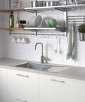 Modern kitchen with white cabinets featuring 30 Pack 6 Inch Brushed Nickel Stainless Steel Cabinet Pulls, with sink and open shelving.