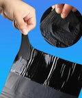 Heavy Duty Asphalt Roof Repair Tape For Sneaky Leaks And Narrow Cracks Waterproof Aluminum Flashing Roll being held, showcasing its thick, flexible design.
