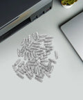 100 Pack Straight Up Sturdy Shelf Pegs For Wood Shelving Heavy Duty Metal Support Pins scattered on a desk near a printer.
