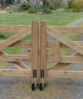 Built Tough As Nails Heavy Duty Gate Caster Wheel With Four Inch Spring Loaded Swivel Roller mounted on wooden gate.