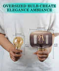 Person holding Amber Diamond Globe LED Edison Bulb 2200K Warm Glow, 4W Dimmable with oversized champagne finish globe.