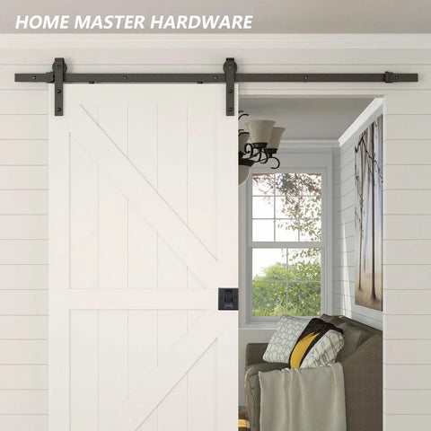 White sliding barn door with Premium Solid Brass Matte Black Pocket Door Lock Pull Set installed in living room entrance.