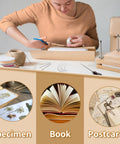 Person using All In One Book Binding Kit With Press And Wooden Binding Press Includes Book Cloth Book Cover Boards Bone Folders Awl Wax Thread Bind Straps And Ribbons For DIY Journal And Album Making Great For Beginners And Crafters at table.