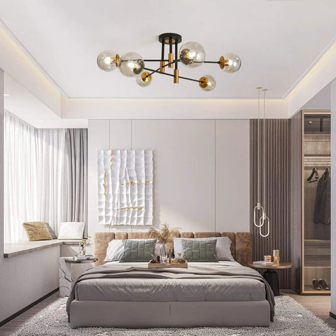 Lit Modern Glass Globe Sputnik Chandelier Flush Mount Ceiling Light In Black And Gold Finish in a modern bedroom setting.