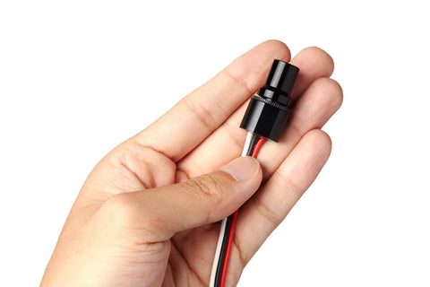 Hand holding Compact LED Dimmer Knob With Rotary Control For 12-24V LEDs, waterproof PWM dimming, built for cars and boats.