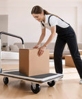 Person using Foldable Push Cart Dolly With 660 Pound Capacity And Swivel Wheels to move a box in a living room setting