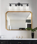 4 Light Vanity Lights Black Wall Sconce With Clear Glass Over Mirror in modern bathroom setting above mirror