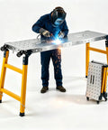 Heavy Duty Folding Welding Table Offering Twelve Hundred Pound Capacity Sixty Six By Seventeen Inch Alloy Steel Workbench in use, welding.