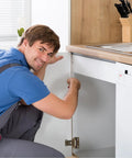 Person installing 4 Pack Golden Iron Kitchen Cabinet Door Hinges with Self Closing Spring, heavy duty for home cabinet replacement.