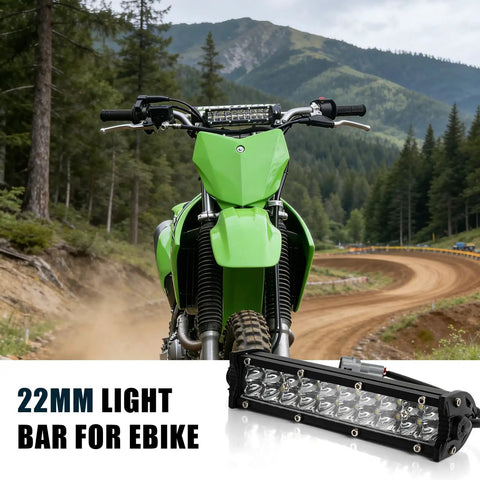 Green dirt bike with 7/8 inch light bar headlight on mountain trail, showcasing universal fit for 22mm handlebars