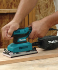Beast Of A Sheet Finishing Sander One Third Inch Orbit, 1.7 Amp, Teal Finish With Ergonomic Rubberized Grip in use on wood