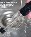 NanoFoamer V2 Milk Foamer For Home Use Microfoamed Milk In 30 Seconds With Dual Speed Waterproof Stainless Steel Build Barista Style Coffee Drinks No Fancy Espresso Rig Needed shown being rinsed under water to demonstrate its waterproof design.