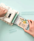 Mini Cinch Binding Tool For DIY Books And Notebooks With Wire Or Spiral Coils Pro Grade Mini Binding Machine in use on a table.