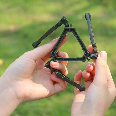 Hands holding a durable camping cookware canister stand with upgraded nylon build and nonslip base, perfect for camp trips.