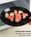 Hand holding a black plate with sushi, demonstrating microwave safety, fits the Camping Utensils Set For One Person description.