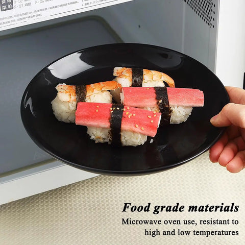 Hand holding a black plate with sushi, demonstrating microwave safety, fits the Camping Utensils Set For One Person description.