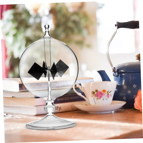 Solar Power Crookes Radiometer Glass Windmill Vane Sunlight Energy Meter Toy For Office on a wooden table beside books