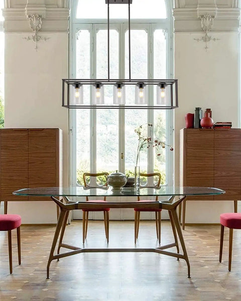 Elegant dining room with modern chandelier above glass table and chairs, showcasing Clear Glass Lamp Shade Replacement Globe for decor.