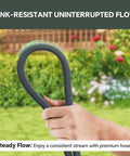 Front view of 75ft non-expanding garden hose, black and gray, looped and held in a hand outdoors