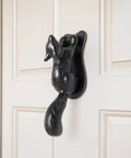 Black Cast Iron Squirrel Shaped Door Knocker With Mounting Hardware on white door, 6.75 inch front door accessory, weatherproof finish