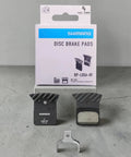 L05A Brake Pads In ACE Ultegra Hard Resin For Road Bikes, Multicolor Set displayed with packaging on concrete surface