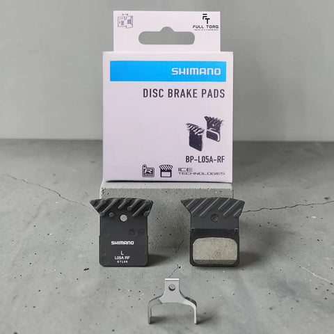 L05A Brake Pads In ACE Ultegra Hard Resin For Road Bikes, Multicolor Set displayed with packaging on concrete surface