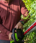 Person using Cordless 24V Hedge Trimmer With 22 Inch Laser Cut Blades, Dual Action Steel, 4Ah Battery And USB Charger Included