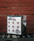 Doghouse FP Archery Target Plus Double Sided Self Standing 24x24x10 Inch Target with target circles against red wooden wall.