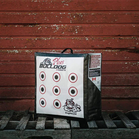 Doghouse FP Archery Target Plus Double Sided Self Standing 24x24x10 Inch Target with target circles against red wooden wall.
