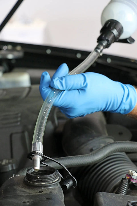 Mityvac MVA6852 1.5L fluid evacuator syringe with clear hose; gloved hand attaching to engine reservoir