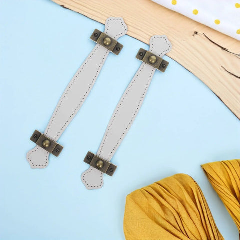 Slick Vintage Zinc Alloy Cabinet Pulls With White PU Leather Grip, 2 Pack laid out on a blue and wood surface