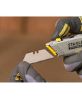 Gloved hands holding 2 In 1 Snap Off Knife Xtreme With Stainless Steel Blade Guide 9mm Width Quick Blade Change Via Notched Wheel No Tools Needed 2 7 16 Inch Blade 6 7 8 Inch Handle Gray showing blade removal