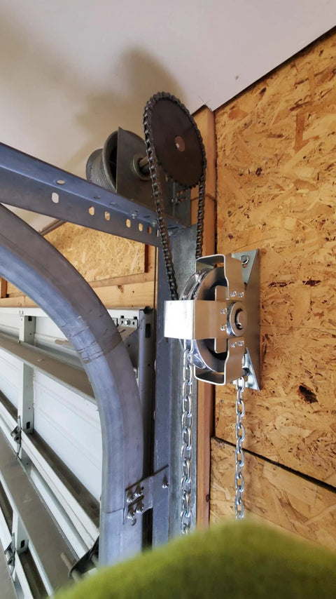 Installed LAJIAOZ garage door jackshaft chain hoist on wall with silver metal housing and drive sprocket