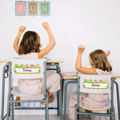 Two children sitting at desks with 50 Pack Hot Air Balloon Style Desk Nameplates For Students on chair backs, bright classroom decor.