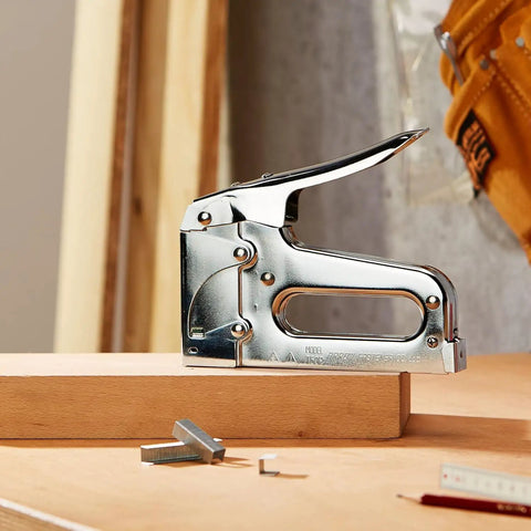 Heavy Duty Staple Gun For Upholstery Woodworking DIY And Pro Projects Manual Stapler shown on wood block with staples nearby