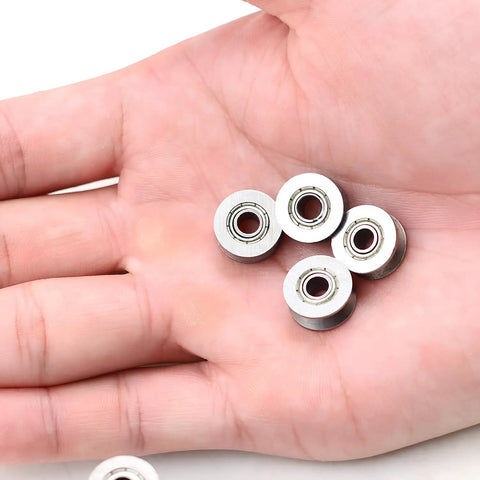 4 mini v groove ball bearings pulleys 4x13x6mm in hand, showcasing steel build for custom DIY projects.