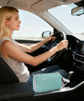 Woman driving car with Insulin Cooler Travel Case With EVA Insulation And Two Ice Packs For Diabetes Care in the center console.