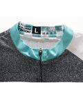 Close-up of a size L black and white sports jacket with turquoise collar detail showing care instructions label.