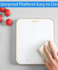 Digital Food Scale 33Lb Capacity With 1g Increments Ultra Precise Kitchen Scale For Cooking And Baking Grams And Ounces LED Display Battery Powered By 3 AAA White being cleaned with a cloth, showing waterproof feature.