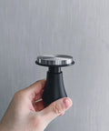 Spring Loaded Espresso Tamper 53.3mm With Ripple Base And Anodized Aluminum Handle held in hand