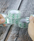 Hands holding Value Pack 48 Clear Tape Rolls for Dispenser 3/4 x 1000 Inches Each 1 Inch Core Go-To Gift Wrapping Tape showing adhesive strip