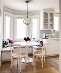 Cozy kitchen with Vintage Wood Pendant Light with Distressed White Finish over table, enhancing rustic ambiance.