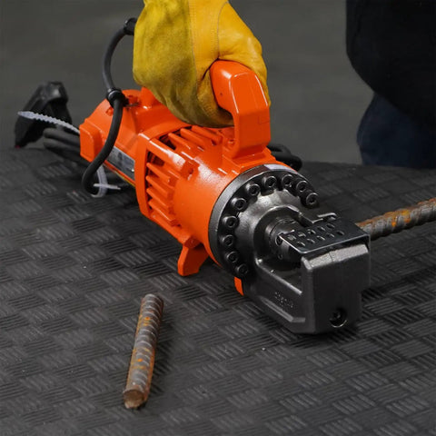 Benner Nawman Dc-20Wh Portable Heavy-Duty Rebar Cutter shown with a gloved hand, cutting rebar on a textured surface.