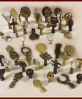 Assorted decorative lamp finials in gold and black featuring various ornate designs and crystal accents on a white background