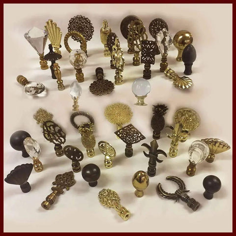 Assorted decorative lamp finials in gold and black featuring various ornate designs and crystal accents on a white background