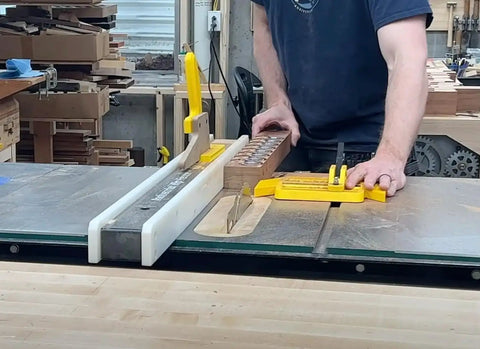 SavR Push Block For Table Saw And Router Table, With Magnetic Fence Mount in use, guiding wood past saw blade with safe grip.