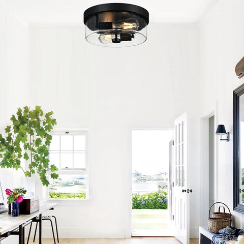 Two Light Black Flush Mount Ceiling Light Fixture with Seeded Glass Shade in bright entryway